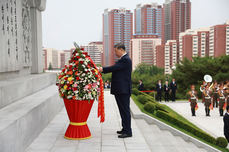 当地时间6月9日上午，正在朝鲜进行国事访问的中共中央总书记、国家主席习近平和夫人彭丽媛参谒中朝友谊塔。朝鲜劳动党总书记、国务委员长金正恩和夫人李雪主陪同。这是习近平整理花篮缎带。图片来源：新华网